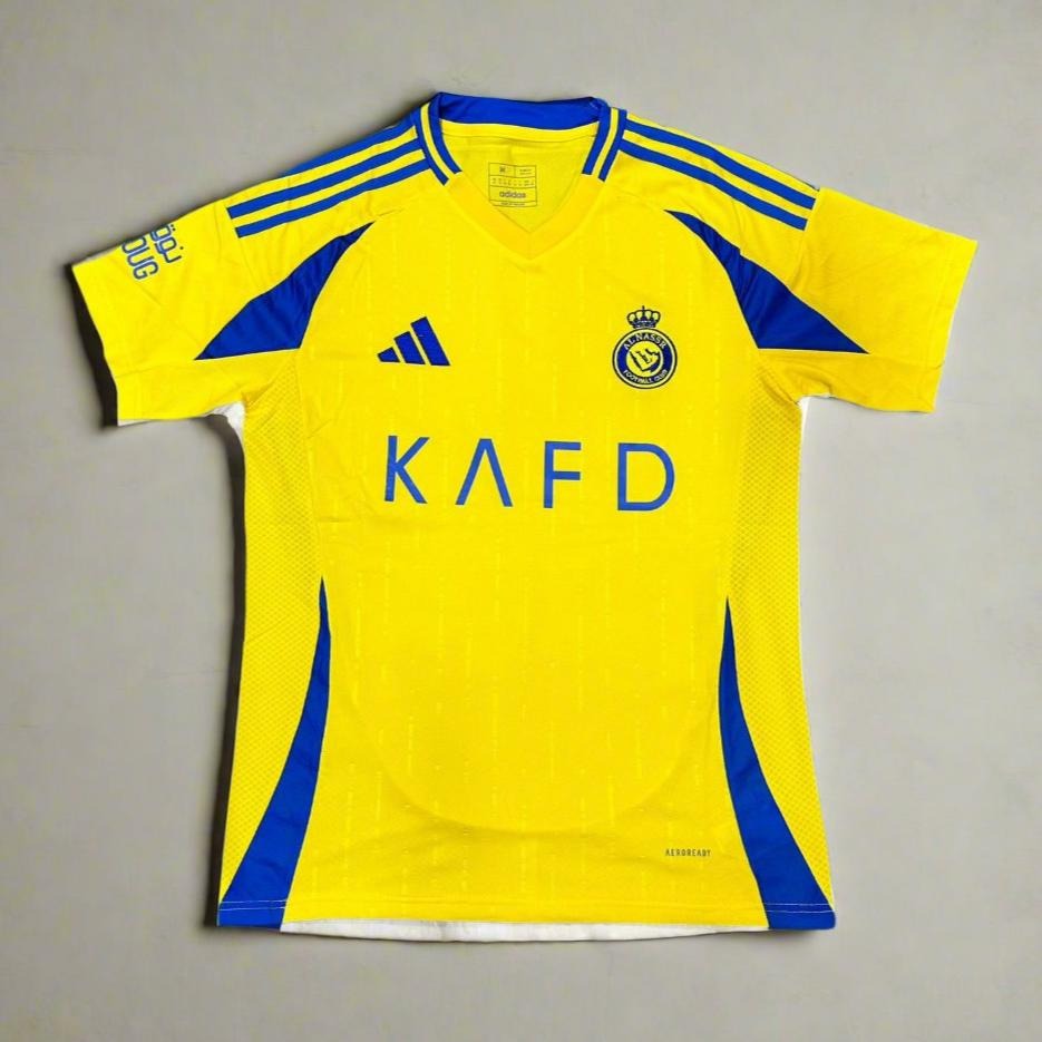 Yellow Al Nassr home football jersey with blue accents and KAFD sponsor logo frnt
